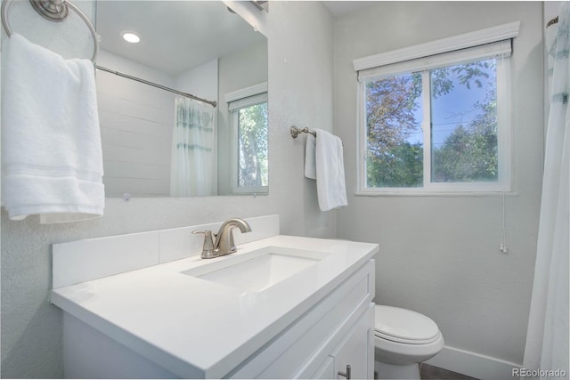 bathroom with a shower with shower curtain, plenty of natural light, toilet, and vanity