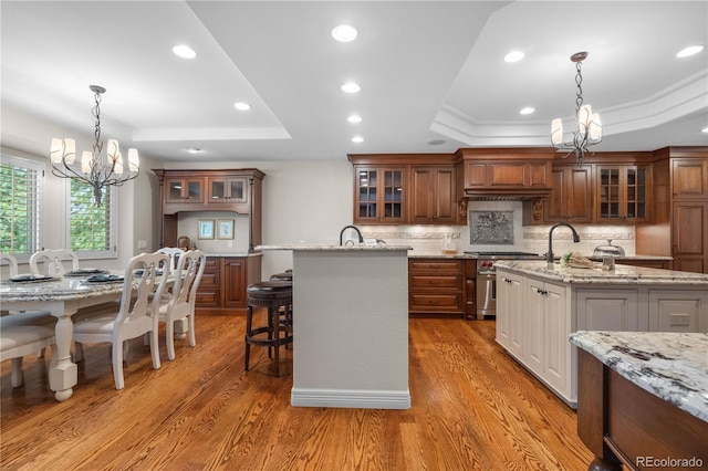 11 Canon Pl, Greenwood Village, CO 80111 - kitchen with a tray ceiling, a chandelier, high end stainless steel range oven, a center island with sink, and recessed lighting
