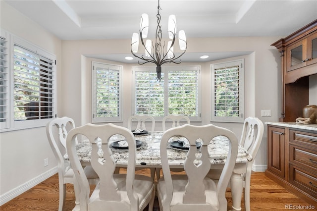 11 Canon Pl, Greenwood Village, CO 80111 - dining area featuring light wood-type flooring, a chandelier, and a tray ceiling