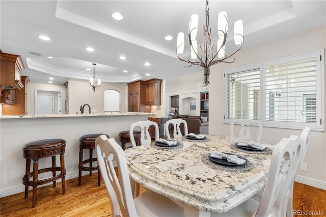 11 Canon Pl, Greenwood Village, CO 80111 - dining space featuring a tray ceiling, a chandelier, light wood-style floors, recessed lighting, and ornamental molding