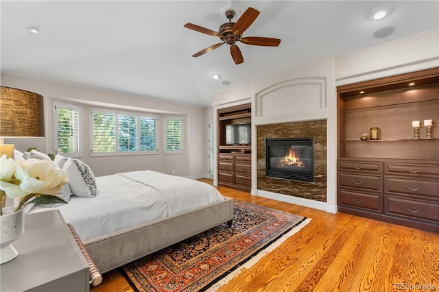 11 Canon Pl, Greenwood Village, CO 80111 - bedroom with lofted ceiling, light wood finished floors, a premium fireplace, a ceiling fan, and recessed lighting