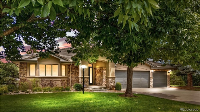 11 Canon Pl, Greenwood Village, CO 80111 - obstructed view of property featuring a garage, stone siding, concrete driveway, a lawn, and stucco siding