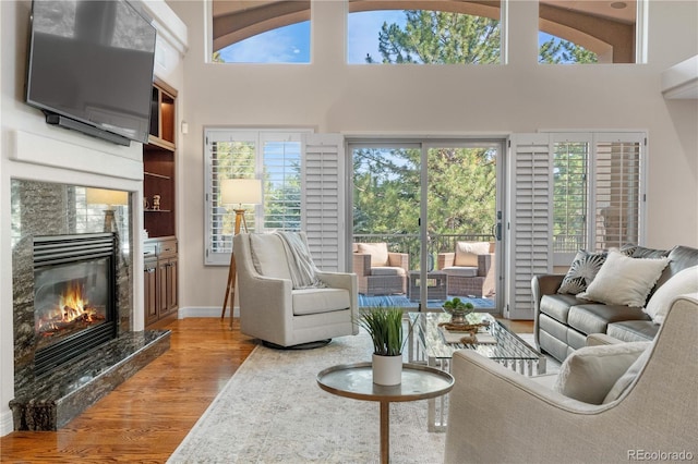 11 Canon Pl, Greenwood Village, CO 80111 - living room featuring wood finished floors, a premium fireplace, healthy amount of natural light, and a towering ceiling