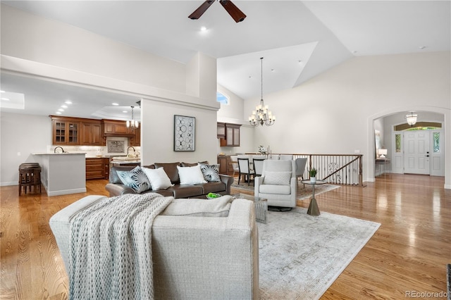 11 Canon Pl, Greenwood Village, CO 80111 - living room featuring ceiling fan, light wood-type flooring, a chandelier, arched walkways, and high vaulted ceiling
