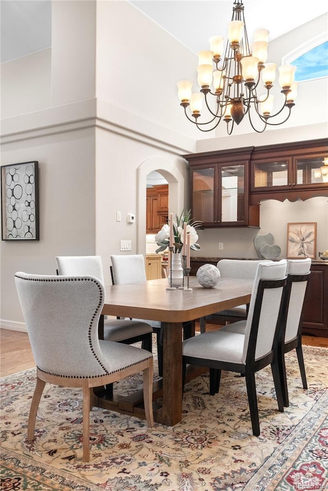 11 Canon Pl, Greenwood Village, CO 80111 - dining area with arched walkways, a chandelier, a high ceiling, and light wood finished floors