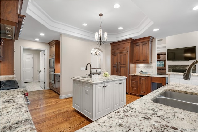 11 Canon Pl, Greenwood Village, CO 80111 - kitchen with a raised ceiling, a chandelier, recessed lighting, stainless steel oven, and light stone counters