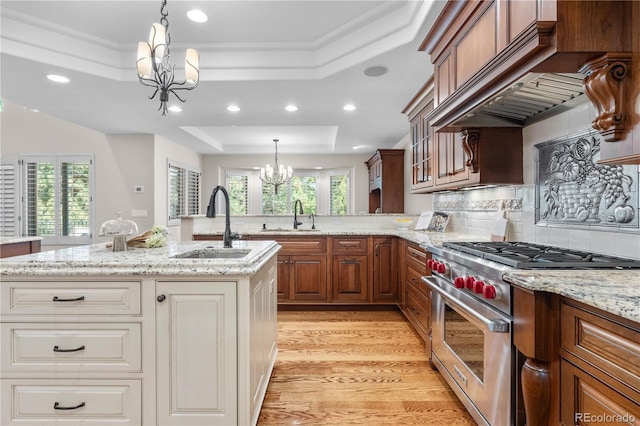 11 Canon Pl, Greenwood Village, CO 80111 - kitchen featuring premium range, a chandelier, a tray ceiling, premium range hood, and light wood-type flooring