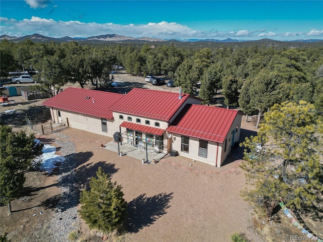 birds eye view of property with a mountain view and a wooded view