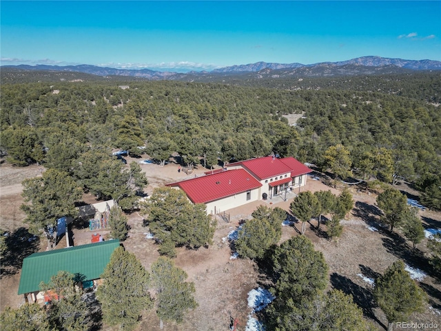 birds eye view of property with a mountain view and a wooded view