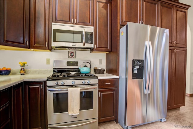 kitchen with stainless steel appliances, light countertops, and light tile patterned floors