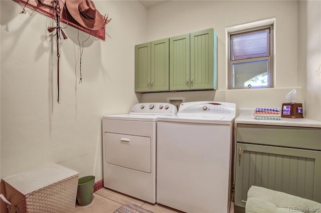 clothes washing area with cabinet space, light tile patterned floors, and washer and dryer