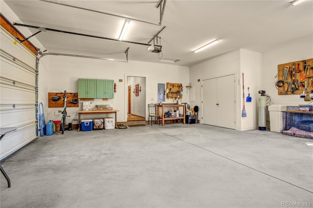 garage with electric panel, a workshop area, and a garage door opener