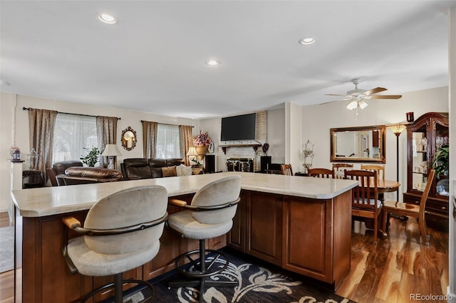 6416 Zang Ct, Arvada, CO 80004 - kitchen featuring light countertops, dark wood finished floors, ceiling fan, a fireplace, and recessed lighting
