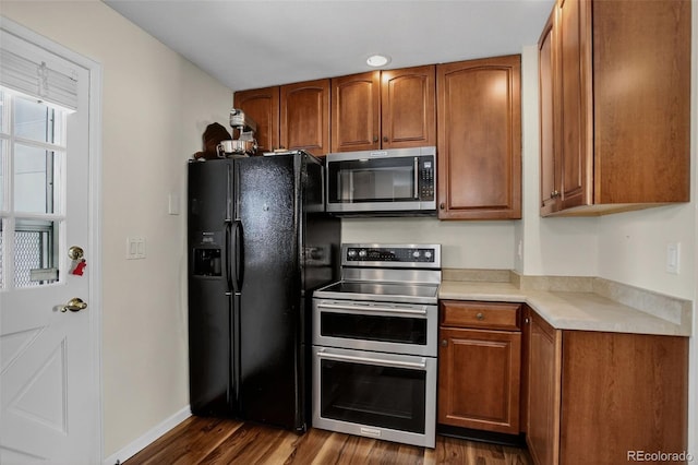 6416 Zang Ct, Arvada, CO 80004 - kitchen with appliances with stainless steel finishes, brown cabinetry, dark wood-style floors, and light countertops