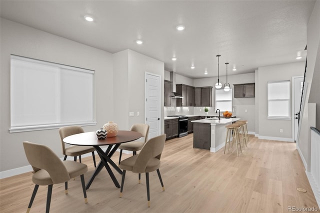 dining space with sink and light hardwood / wood-style floors