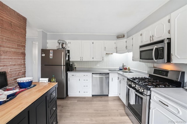 11827 Brook Rd, Golden, CO 80403 - kitchen featuring stainless steel appliances, white cabinetry, light wood finished floors, crown molding, and decorative backsplash