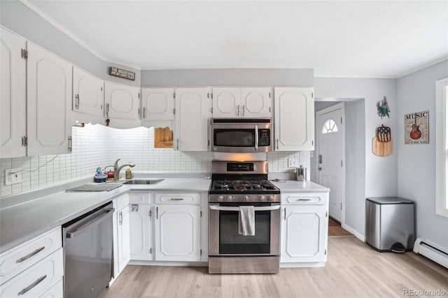 11827 Brook Rd, Golden, CO 80403 - kitchen with stainless steel appliances, baseboard heating, white cabinets, tasteful backsplash, and ornamental molding