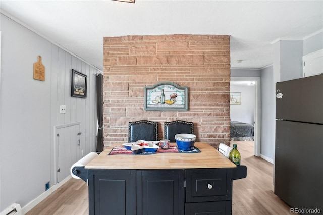 11827 Brook Rd, Golden, CO 80403 - kitchen featuring freestanding refrigerator, a baseboard heating unit, crown molding, light wood-type flooring, and baseboards