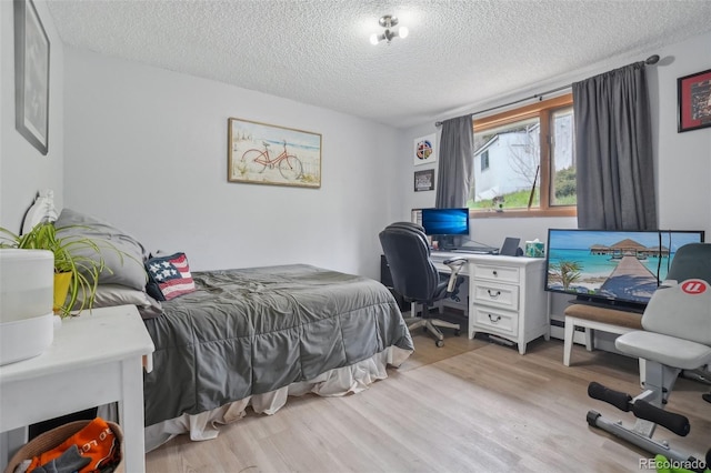 11827 Brook Rd, Golden, CO 80403 - bedroom featuring a textured ceiling, light wood-style flooring, a desk, and baseboard heating