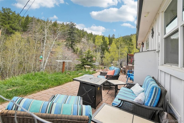 11827 Brook Rd, Golden, CO 80403 - view of patio with an outdoor living space with a fire pit and a wooded view