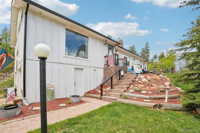 11827 Brook Rd, Golden, CO 80403 - view of property exterior with board and batten siding, a chimney, and stairway