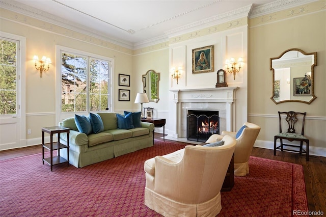 living room featuring a high end fireplace, wood finished floors, baseboards, and ornamental molding