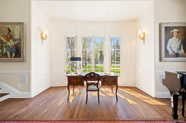 office area featuring a decorative wall and wood finished floors