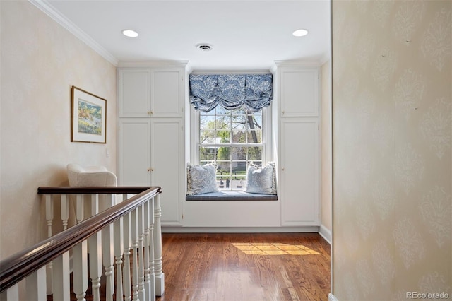 hallway with wood finished floors, ornamental molding, and recessed lighting