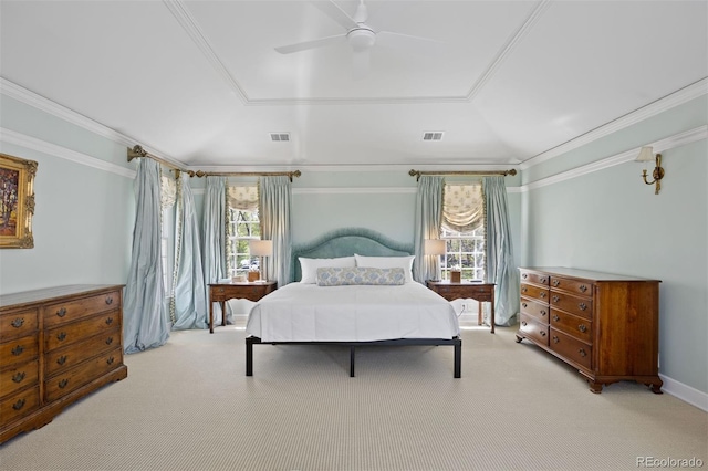 bedroom featuring multiple windows, light carpet, a ceiling fan, ornamental molding, and a tray ceiling