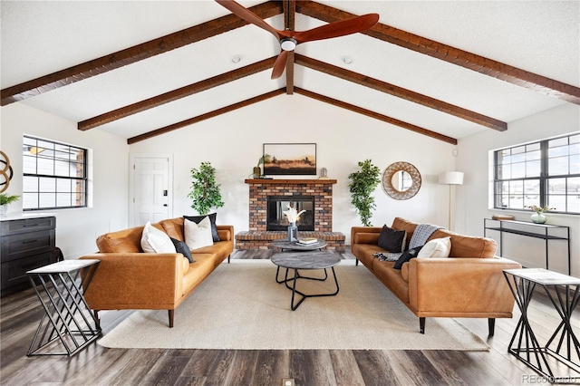 living area with plenty of natural light, a brick fireplace, and wood finished floors