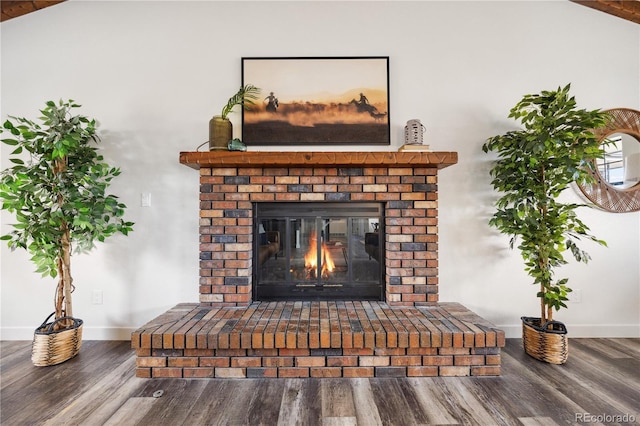 interior details featuring a brick fireplace, wood finished floors, and baseboards