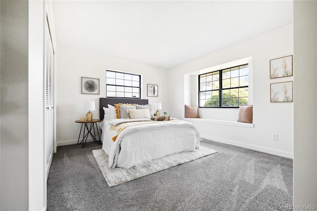 carpeted bedroom featuring baseboards and multiple windows