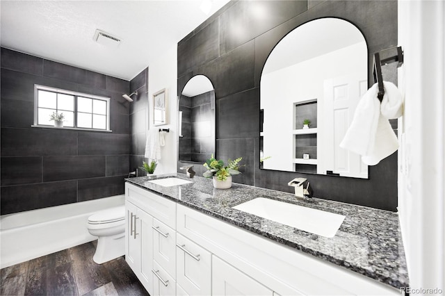 bathroom with a sink, visible vents, toilet, and wood finished floors