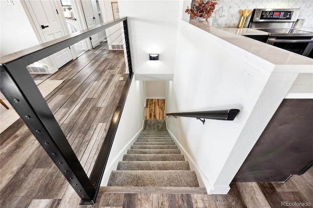 staircase featuring visible vents, baseboards, and wood finished floors