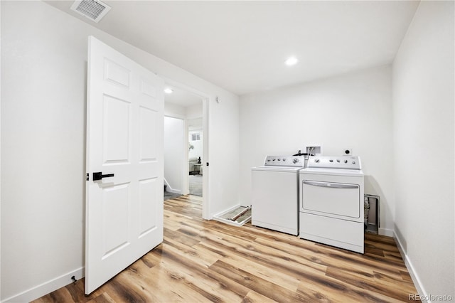 laundry area featuring visible vents, independent washer and dryer, laundry area, and light wood-style floors