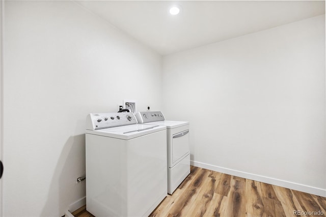 clothes washing area with baseboards, light wood finished floors, laundry area, recessed lighting, and washer and dryer