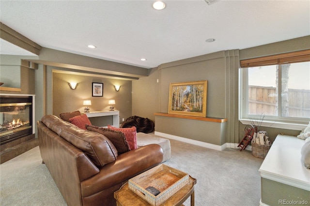 living room with light colored carpet, a multi sided fireplace, baseboards, and recessed lighting