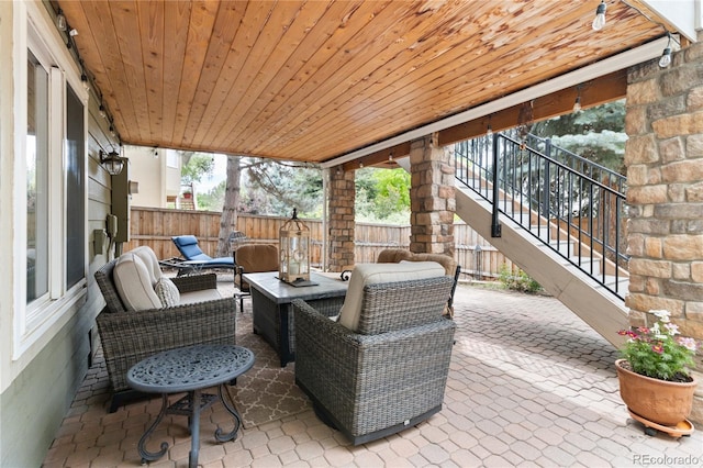 view of patio / terrace featuring stairs, a fenced backyard, and an outdoor living space