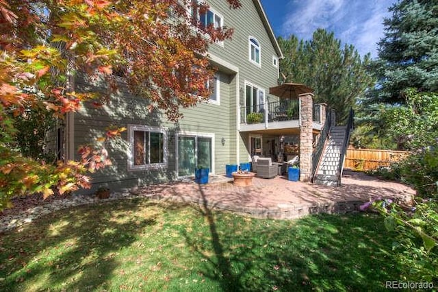 rear view of property featuring a patio area, stairway, and a balcony