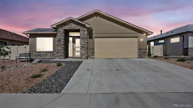 681 Eadin Ln, Grand Junction, CO 81504 - view of front of property with stone siding, an attached garage, and concrete driveway