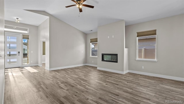 681 Eadin Ln, Grand Junction, CO 81504 - unfurnished living room featuring wood finished floors, ceiling fan, a glass covered fireplace, and lofted ceiling