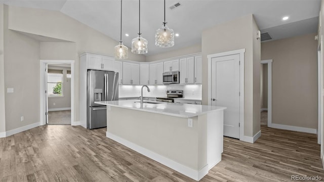 681 Eadin Ln, Grand Junction, CO 81504 - kitchen with stainless steel appliances, tasteful backsplash, white cabinets, light countertops, and an island with sink