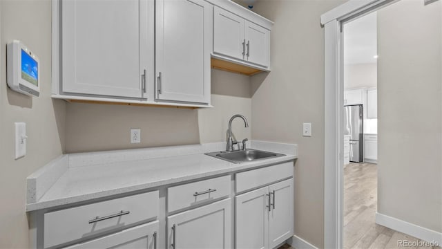 681 Eadin Ln, Grand Junction, CO 81504 - kitchen featuring freestanding refrigerator, white cabinets, light wood-style flooring, and light stone counters