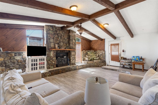 living room featuring vaulted ceiling with beams, a textured ceiling, and wood finished floors