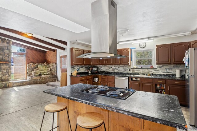 kitchen featuring backsplash, cooktop, dishwasher, island range hood, and a sink