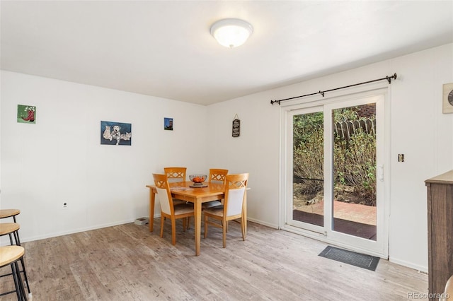 dining room featuring light wood finished floors and baseboards