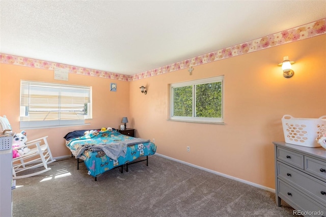 carpeted bedroom with a textured ceiling and baseboards