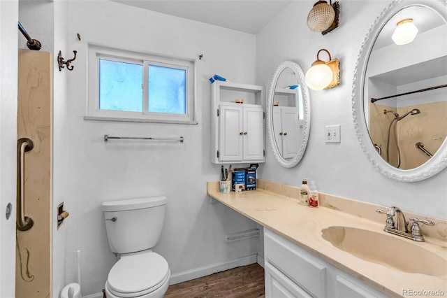 full bathroom with vanity, wood finished floors, baseboards, a shower, and toilet