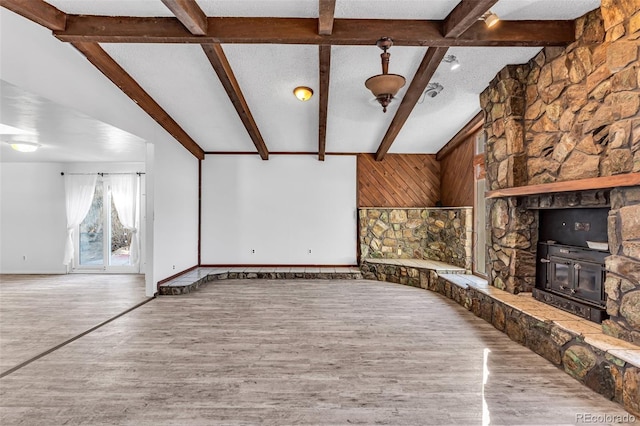 unfurnished living room with wood finished floors, baseboards, and a textured ceiling