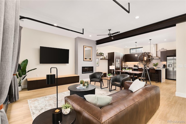 living area featuring recessed lighting, light wood-style floors, baseboards, and ceiling fan